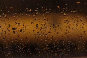 Drops of rain on the glass of the window,  the night
