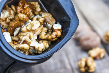 Walnut kernels in a coffee grinder on an old wooden table.