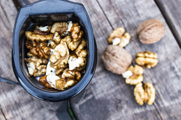Walnut kernels in a coffee grinder on an old wooden table.