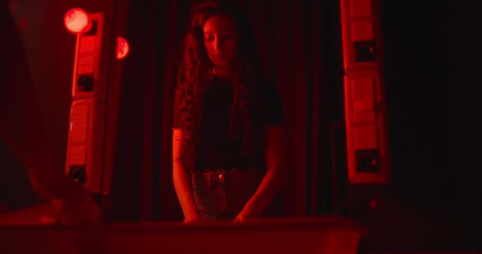 young woman develops a sheet of photographic paper in the dark room