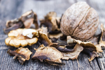 Walnut kernels and partitions near whole walnuts on a wooden table. The medicine for tinctures and decoctions.