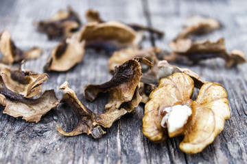 Walnut kernels and partitions near whole walnuts on a wooden table. The medicine for tinctures and decoctions.