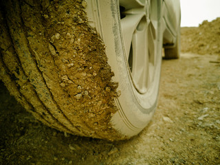 this picture is film grain style, off road car on non asphalt road, rear wheel is dirty,  this...