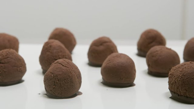 Chocolate truffles on a conveyor belt at candy factory