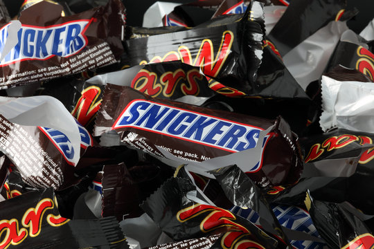Tambov, Russian Federation - September 02, 2012: Empty sweet wrappers of Snickers and Mars minis candy bars heap. Full Frame. 