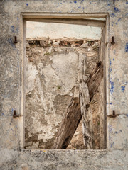 view through a window of a abandoned and ruined house in the village of Palia Plagia, Greece, hit by an earthquake