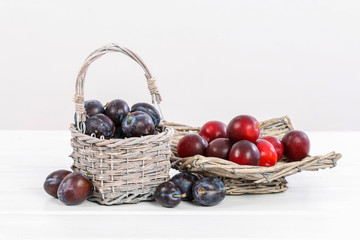 Wicker basket with ripe plums.