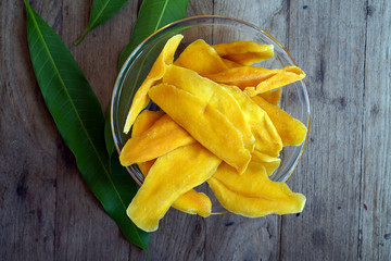 Dehydrated Mango Slices in Glass Bowl with mango leaf 