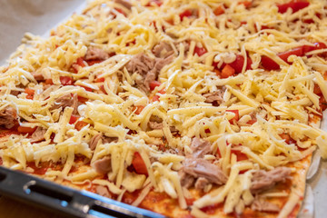 Leckere italienische Pizza schmeckt selbstgemacht und frisch aus dem Ofen mit Thunfisch und Paprika mit Käse überbacken wie Italien zu Hause beim Abendessen