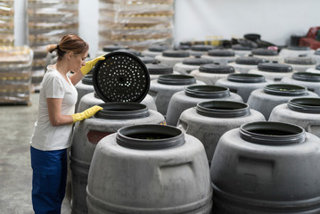 Woman in olives warehouse factory controlling fruits fermentation