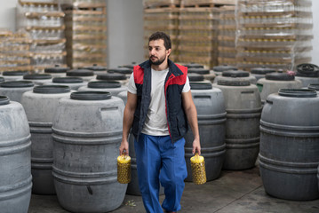 Man walking with olives bottle in factory