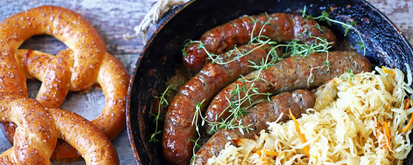 Oktoberfest food. Hot Bavarian sausages with sauerkraut in a pan. Delicious beer festival food