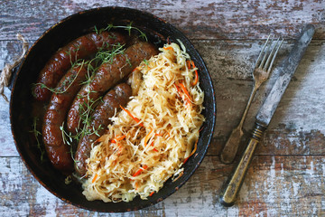 Oktoberfest food. Hot Bavarian sausages with sauerkraut in a pan. Delicious beer festival food