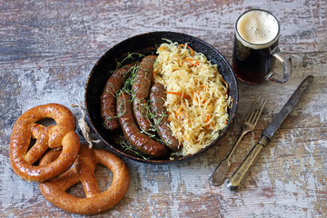 Oktoberfest food. Hot Bavarian sausages with sauerkraut in a pan. Delicious beer festival food
