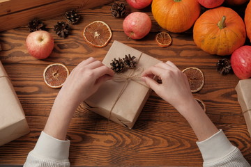 hands hold gift boxes, pumpkins garlands