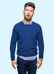 Young handsome bussines man In shock face, looking skeptical and sarcastic, surprised with open mouth