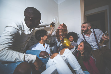 A group of young people celebrating and making party at home - obrazy, fototapety, plakaty