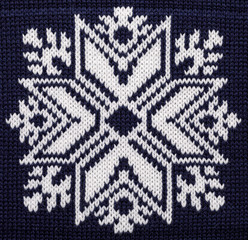White knitted snowflake ornament on blue Christmas sweater
