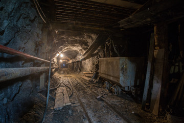 Fototapeta na wymiar Gold mine ore shaft tunnel with wagon minecart