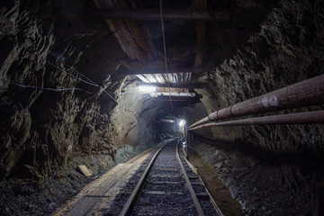 Naklejka premium Gold mine ore shaft tunnel with rails
