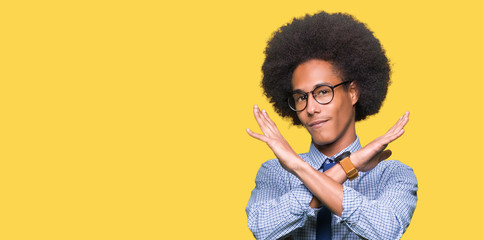 Young african american business man with afro hair wearing glasses Rejection expression crossing arms doing negative sign, angry face