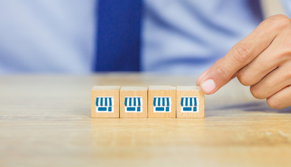 Franchise business concept , businessman hand choose wood blog with franchise marketing.