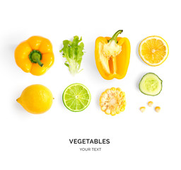 Creative layout made of yellow pepper, lemon, lime, corn and lettuce. Flat lay. Food concept. Yellow vegetables isolated on white background.