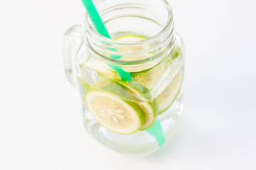 glass of water with lemon on white background