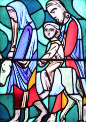 Fototapeta na wymiar Flight into Egypt, stained glass window in Basilica of St. Vitus in Ellwangen, Germany