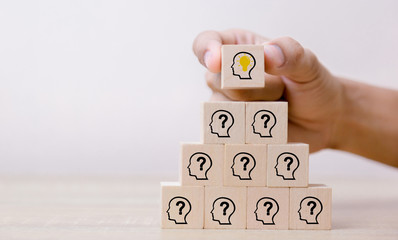 Hand arranging wood block with icon head human symbol and light bulb,concept creative idea and...