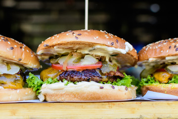 Close up of a tasty hamburger sandwich, with grilled spiced meat with tomato, cucumber and mayonnaise, displayed for sale at an weekend street food market