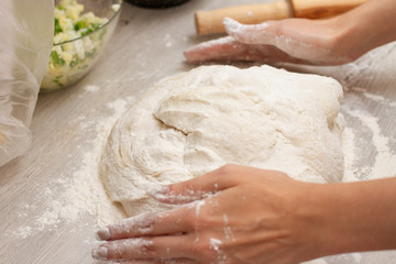 women hands making dough on a table with flour for pies