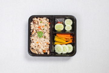 Fried rice with fried tuna put in black plastic box, put on a white tablecloth, food box, Thai food.