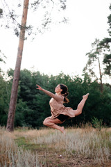 girl dancing in the summer in a pine forest