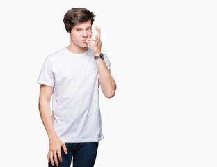 Young handsome man wearing casual white t-shirt over isolated background mouth and lips shut as zip...
