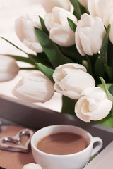 Spring flowers. Bouquet of white tulips in a vase on the bedside table. Shallow depth of field	