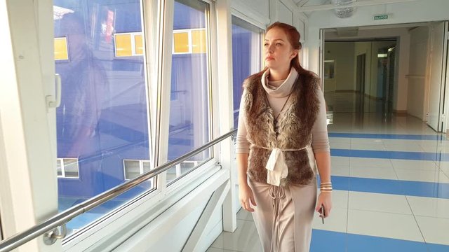 glamorous woman goes on transition in business center.
