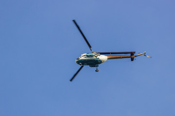 Helicopter flying in the sky. Helicopter against the blue sky.