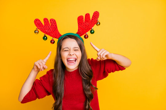 Portrait of funny funky crazy brunette hair kid point index finger her reindeer horns headband laughing have fun christmas theme costume party wear stylish sweater isolated bright color background
