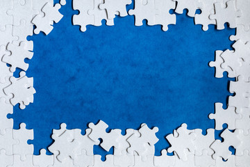 White jigsaw puzzle. White puzzle pieces on color background. Unfinished white jigsaw puzzle pieces...