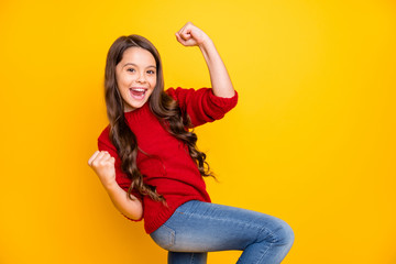 Yeah I champion. Portrait of positive cheerful kid feel crazy funky raise fists celebrate victory in lottery competition wear lifestyle clothes pullover denim jeans isolated yellow color background