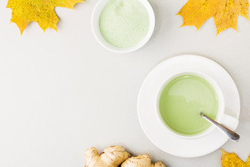 Top view of green tea matcha in a white mug. Matcha ginger latte. Concept - healthy autumn drinks. Copy space for text