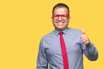 Middle age arab man wearing fashion red glasses over isolated background doing happy thumbs up gesture with hand. Approving expression looking at the camera with showing success.