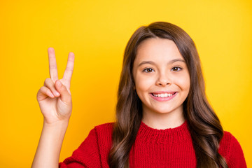 Close up photo of positive cheerful content kid have fun on autumn vacations make v-signs wear good look clothes isolated over yellow color background