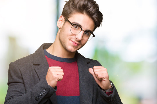 Young handsome elegant man wearing glasses over isolated background looking confident with smile on face, pointing oneself with fingers proud and happy.