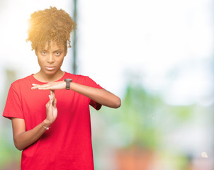 Beautiful young african american woman over isolated background Doing time out gesture with hands,...