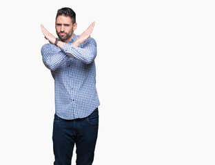 Young handsome man over isolated background Rejection expression crossing arms doing negative sign, angry face