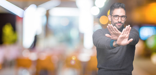 Fototapeta na wymiar Young handsome man wearing glasses over isolated background Rejection expression crossing arms and palms doing negative sign, angry face