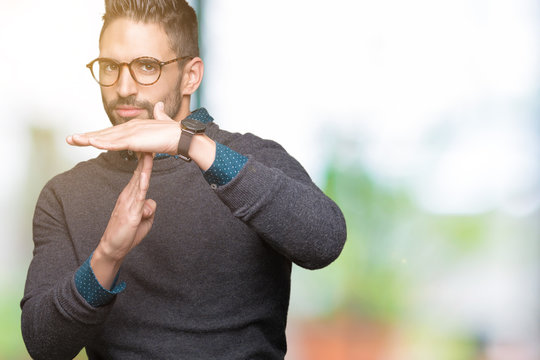 Young handsome man wearing glasses over isolated background Doing time out gesture with hands, frustrated and serious face