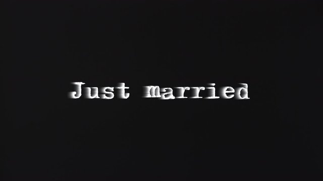 A scary text, Just Married, appearing on the screen with a light behind the typewriter font, typical of a horror flick (b-movie).